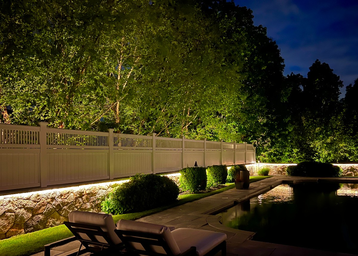 Professionally installed backyard lighting installation by NightView Outdoor Lighting illuminating a fence line and garden pathway with warm LED fixtures